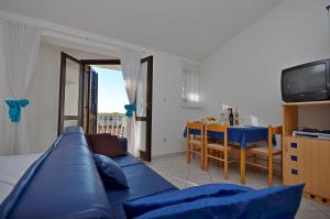 a living room with a blue couch and a table at Apartments Mira in Tribunj