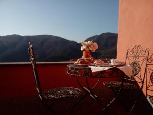 ヴァード・リーグレにあるContrada casa vacanzeの山々を背景にテーブルと椅子が備わるバルコニー