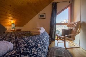 a bedroom with a bed and a chair and a window at Fresh Tracks - Chalet L Etendard in Oz