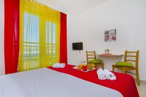 a bedroom with a bed with red and yellow curtains at Apartments Pava in Okrug Donji