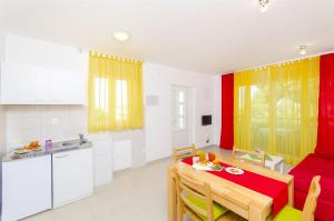 eine Küche und ein Esszimmer mit einem Tisch und einer Küche in der Unterkunft Apartments Pava in Okrug Donji