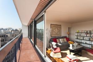 ein Wohnzimmer mit einem Sofa und einem Balkon in der Unterkunft Appartement le Méridien in Paris