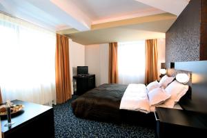 Habitación de hotel con cama y escritorio en Ambiance Hotel, en Bucarest