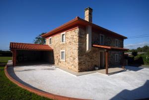 een groot bakstenen huis met een grote garage bij Casa Rural Pantin in Valdoviño