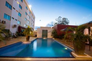 a swimming pool in front of a building at Pumma Business Hotel in Canaã dos Carajás