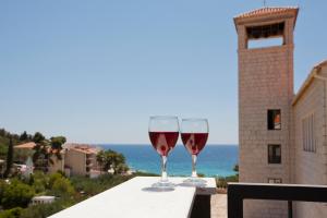 two glasses of red wine sitting on a table at Luxurious Apartments Maslina with Beach in Milna