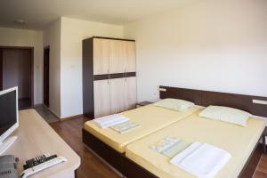 a bedroom with a bed and a cabinet and a television at Guest House Georgievi in Primorsko