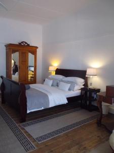 1 dormitorio con 1 cama grande y espejo en Breeze Inn Guesthouse, en Kiddʼs Beach