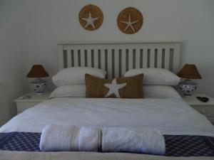 1 dormitorio con 2 camas con almohadas y 2 lámparas en Breeze Inn Guesthouse, en Kiddʼs Beach