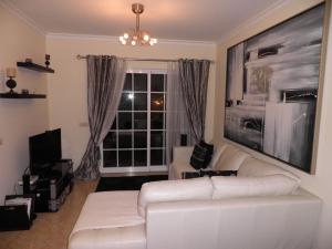 uma sala de estar com um sofá branco e uma janela em Holiday Home Salgados em Albufeira