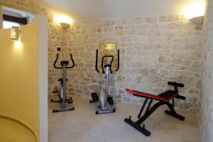 einen Fitnessraum mit Trainingsgeräten in einem Zimmer in der Unterkunft Il Borgo Delle Querce Villa Fichi Piscina privata in Martina Franca