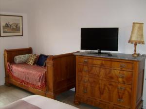 1 dormitorio con tocador y TV encima. en Maison des Isles, en Saint-Hilaire-du-Harcouët