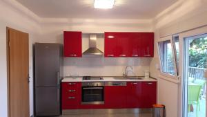 a kitchen with red cabinets and a stainless steel refrigerator at Apartment Branko in Vinišće
