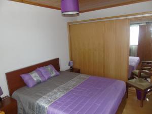 1 dormitorio con 1 cama de color púrpura y 1 silla en Azoresmoonlight, en Capelo