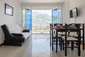 a living room with a couch and a table and chairs at Apartments Riverside in Herceg-Novi
