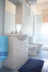 a white bathroom with a sink and a toilet at Stefy Home in Catania