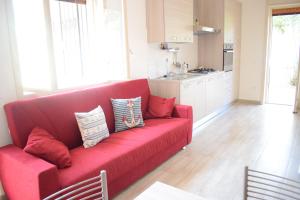 a red couch in a living room with a kitchen at Stefy Home in Catania