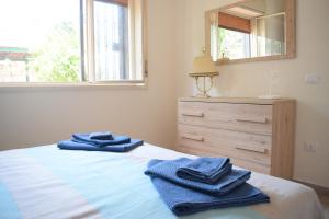 a bedroom with blue towels on a bed with a dresser at Stefy Home in Catania