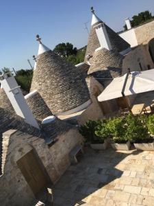 a building with strawitious roofs with plants and a patio at Trulli di Pozzomasiello in Locorotondo