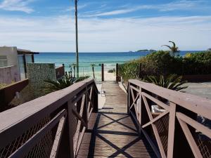 Un paseo marítimo hasta la playa con el océano al fondo en Palm Beach Apart Hotel, en Florianópolis