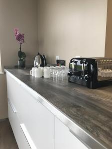 a kitchen counter with a toaster and cups on it at Vagnsstadir Guesthouse in Borgarhöfn