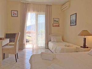 a bedroom with two beds and a desk and a window at Apartments Stanisic in Herceg-Novi +61 photos