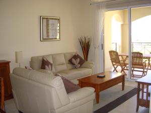 a living room with a couch and a coffee table at Mazotos Panoramic Village in Mazotos