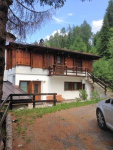 une maison avec un balcon et une voiture garée devant elle dans l'établissement Villa Gaia, à Folgarida