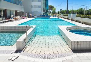 a large swimming pool in a building at Hotel Ascot & Spa in Rimini