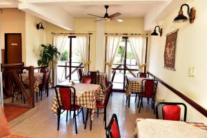 un comedor con mesas, sillas y ventanas en Hotel Gran Litoral en Concepción del Uruguay