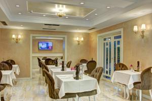 a restaurant with tables and chairs and a tv at Lot Boutique Hotel by Hotels and Preference in Tirana