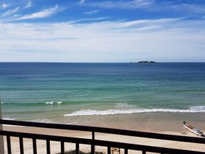 a view of the ocean from a balcony of a beach at Palm Beach Apart Hotel in Florianópolis