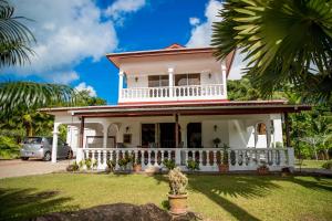 ein weißes Haus mit einer Palme in der Unterkunft The Orchard Holiday Home in Mahé