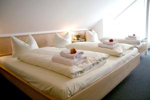 three beds with towels and fruit on top of them at Gasthaus zur Linde in Hohenpolding