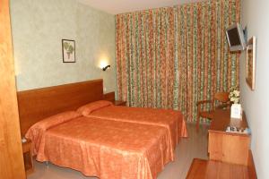 a hotel room with two beds and two lamps at Hotel Fonda Neus in Sant Sadurní dʼAnoia