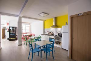 uma cozinha com mesa e cadeiras e uma cozinha com paredes amarelas em Albergue As Pedreiras em Collado Villalba