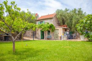 ディアーノ・マリーナにあるCountry Home il Passatempoの木の植わる緑の庭のある家