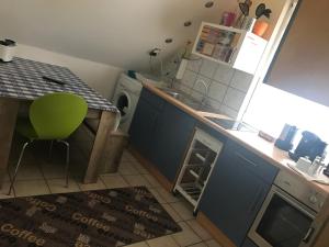 a small kitchen with a sink and a washing machine at Messe Apartment & Rooms Hänigsen in Hänigsen