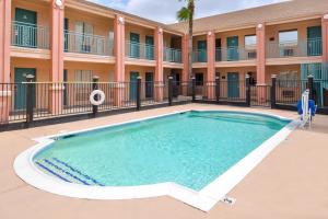 a swimming pool in front of a building with a hotel at Americas Best Value Inn Clute in Clute