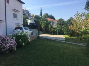 a yard of a house with a car parked next to it at Aničić in Opatija