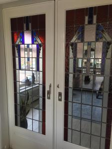 a pair of doors with stained glass windows at Tastefull double story 2 bedroom appartment/house in Haarlem