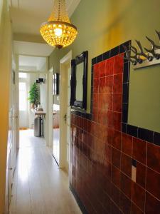 a hallway with a tile wall and a chandelier at Tastefull double story 2 bedroom appartment/house in Haarlem