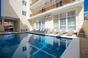 a swimming pool in front of a building at Hotel Greek in Vityazevo