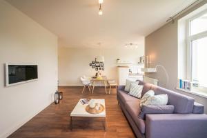 ein Wohnzimmer mit einem Sofa und einem Tisch in der Unterkunft Gutshaus Krummin Usedom in Krummin