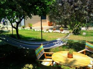 een hangmat in een tuin met een tafel en stoelen bij B&B La Palma in Petacciato