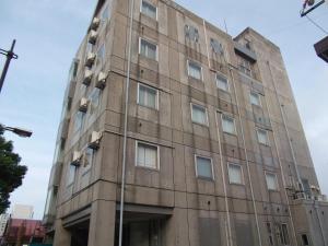 un viejo edificio en la esquina de una calle en Asahi City Inn Hotel en Takaoka