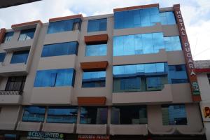 un edificio de oficinas con ventanas azules en Hostal Pucará, en Loja
