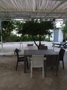 a table and chairs with a table and a tree at House Matale Savelletri in Savelletri di Fasano