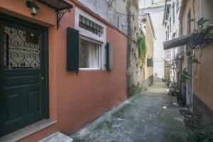 an alley with a green door and a building at S&G Corfu Old Town Apartments in Corfu