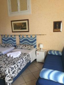 - une chambre avec 2 lits avec des draps bleus et blancs dans l'établissement B&B Anfiteatro Campano, à Santa Maria Capua Vetere